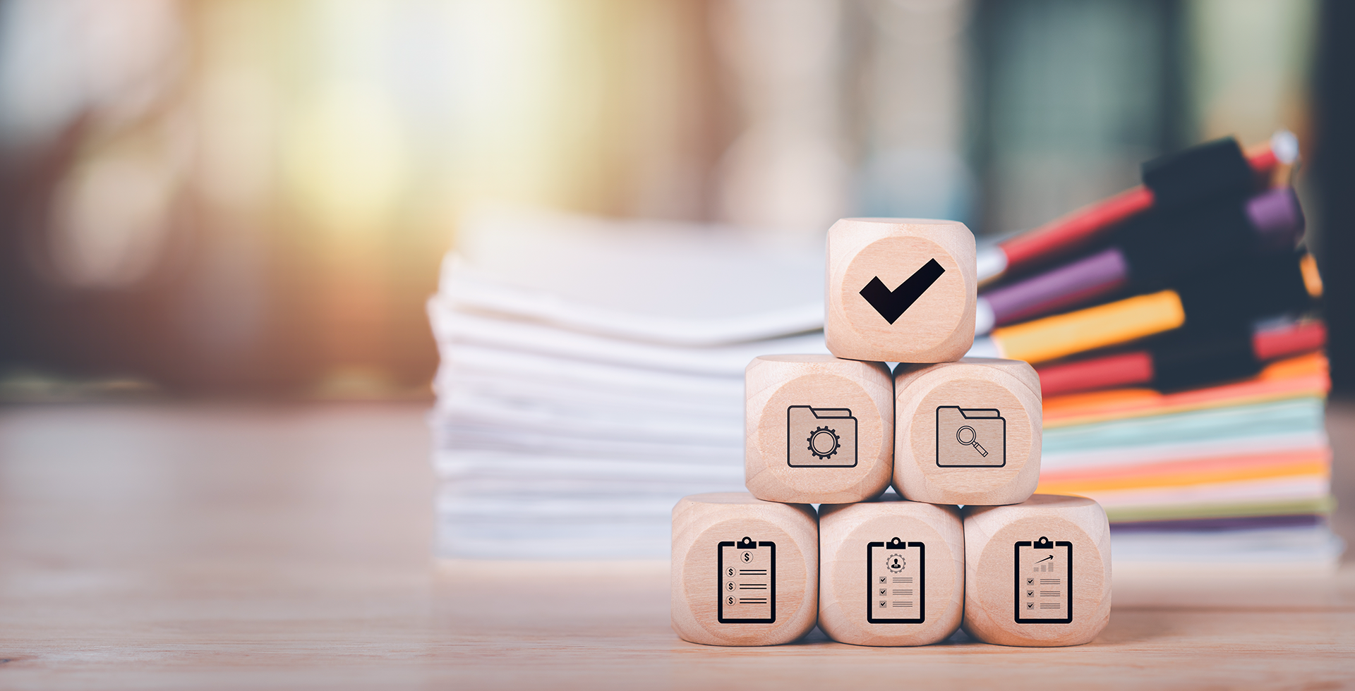 A stack of wooden blocks with a check mark on top.